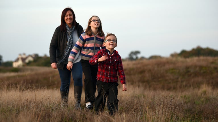 Visitors walking on the Royal Burial Ground in autumn at Sutton Hoo, Suffolk